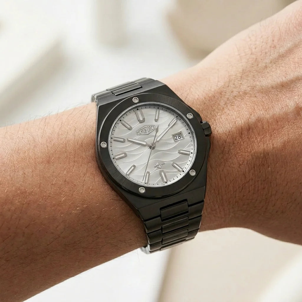 Black stainless steel wristwatch with a silver wave patterned dial worn on a person's wrist