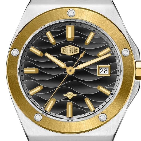 Close up of a black wave patterned watch dial with gold hour markers, gold bezel, and date display.