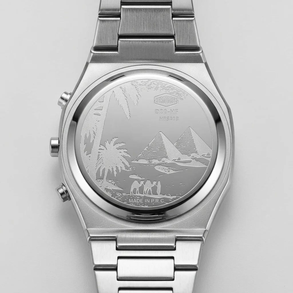 Silver stainless steel wrist watch with a metal link bracelet, featuring an engraved Egyptian desert scene on the back case with pyramids, palm trees, and figures.