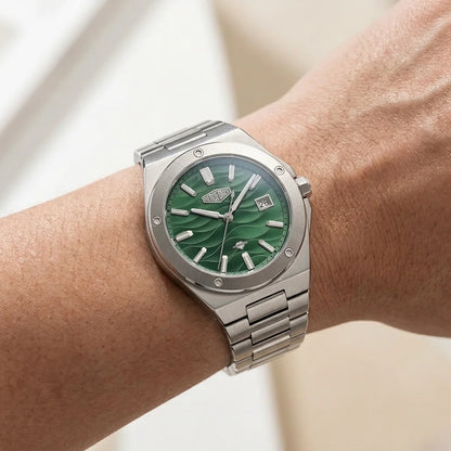 Stainless steel wristwatch with a green wave patterned on a hand