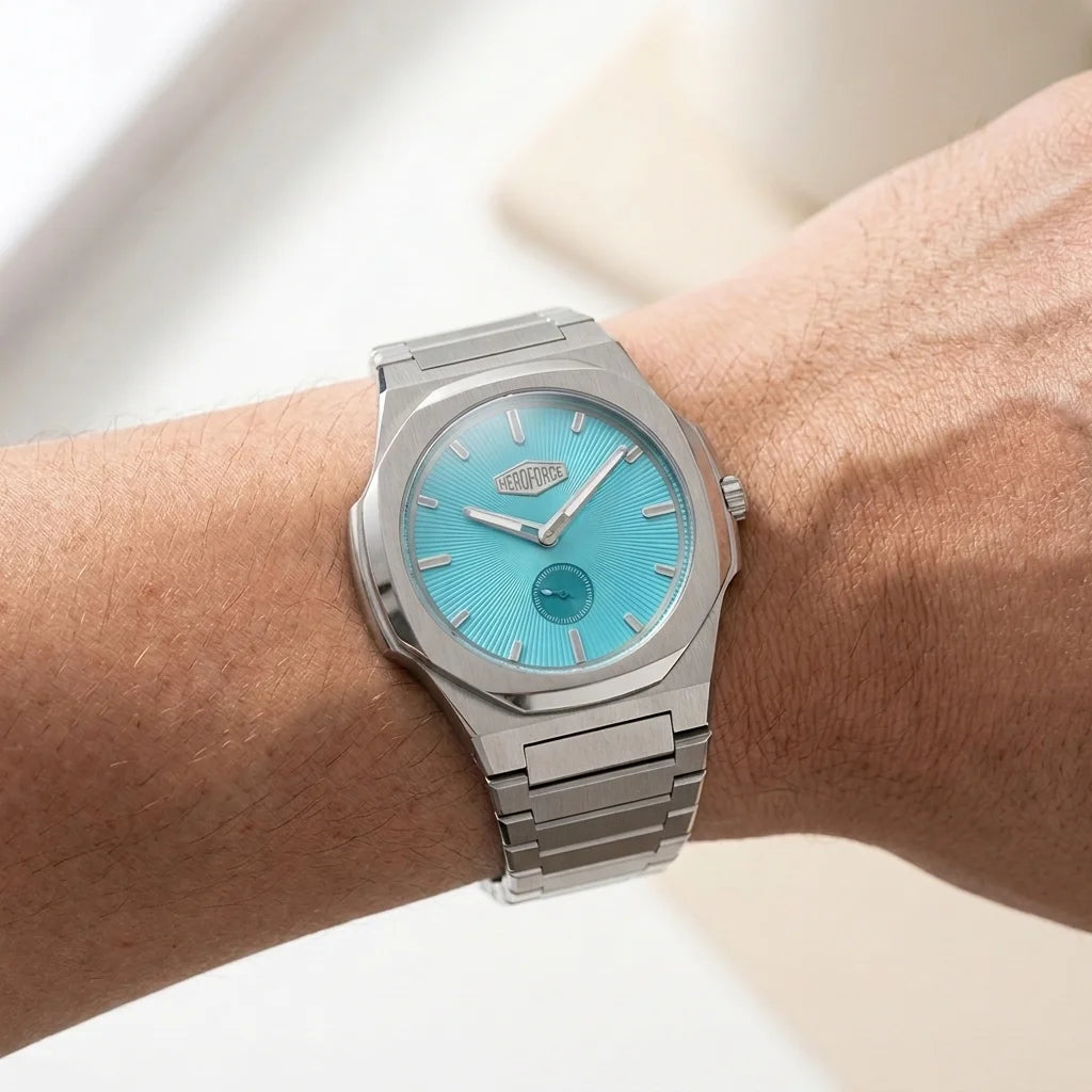 Watch on wrist- Stainless steel wristwatch with turquoise sunburst dial, silver markers, and small seconds subdial